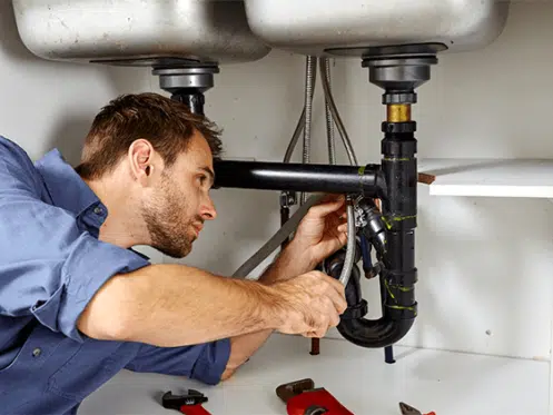 plumber repairing sink drain 497x373 2